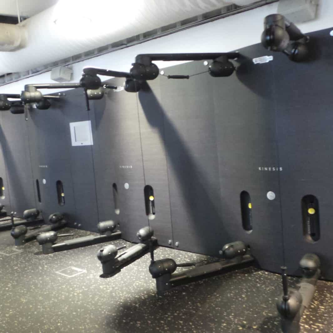 row of Technogym Kinesis Wall x4 Plus TV Screen Wall installed in a gym