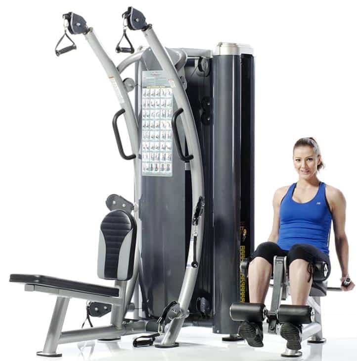trainer doing leg extensions on the TuffStuff Dual Stack Functional Trainer (HTX-2000)