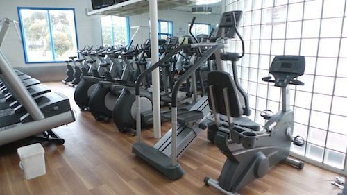 Row of stationary exercise machines at a gym